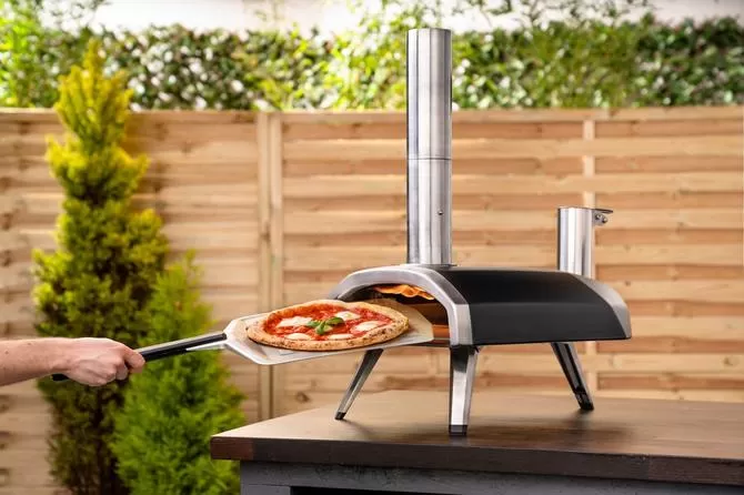 taking pizza out from ooni fyra 12