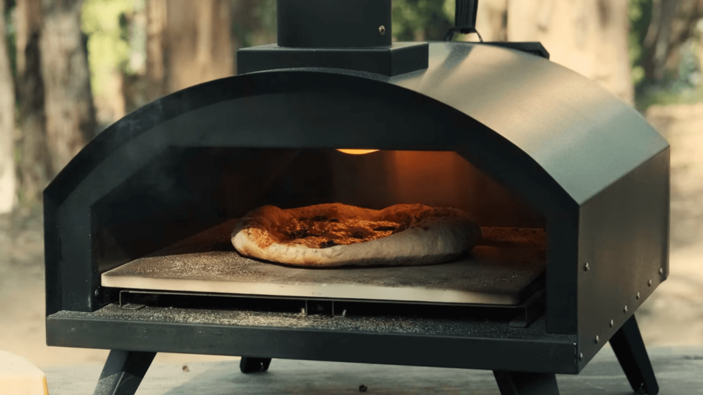 close up image of wood fire pizza oven with pizza inside